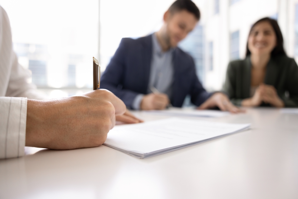 deux personnes discutant d'un accord de logement partagé autour d'une table avec des documents